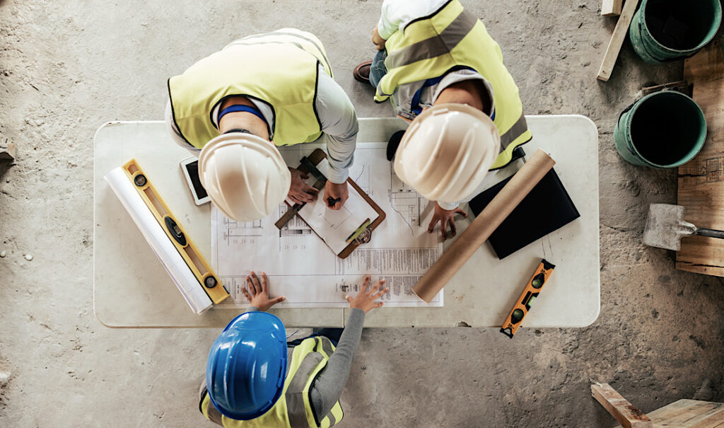 Construction company evaluating a blueprint. Invest in commercial insurance for your small business in Castle Rock, CO.